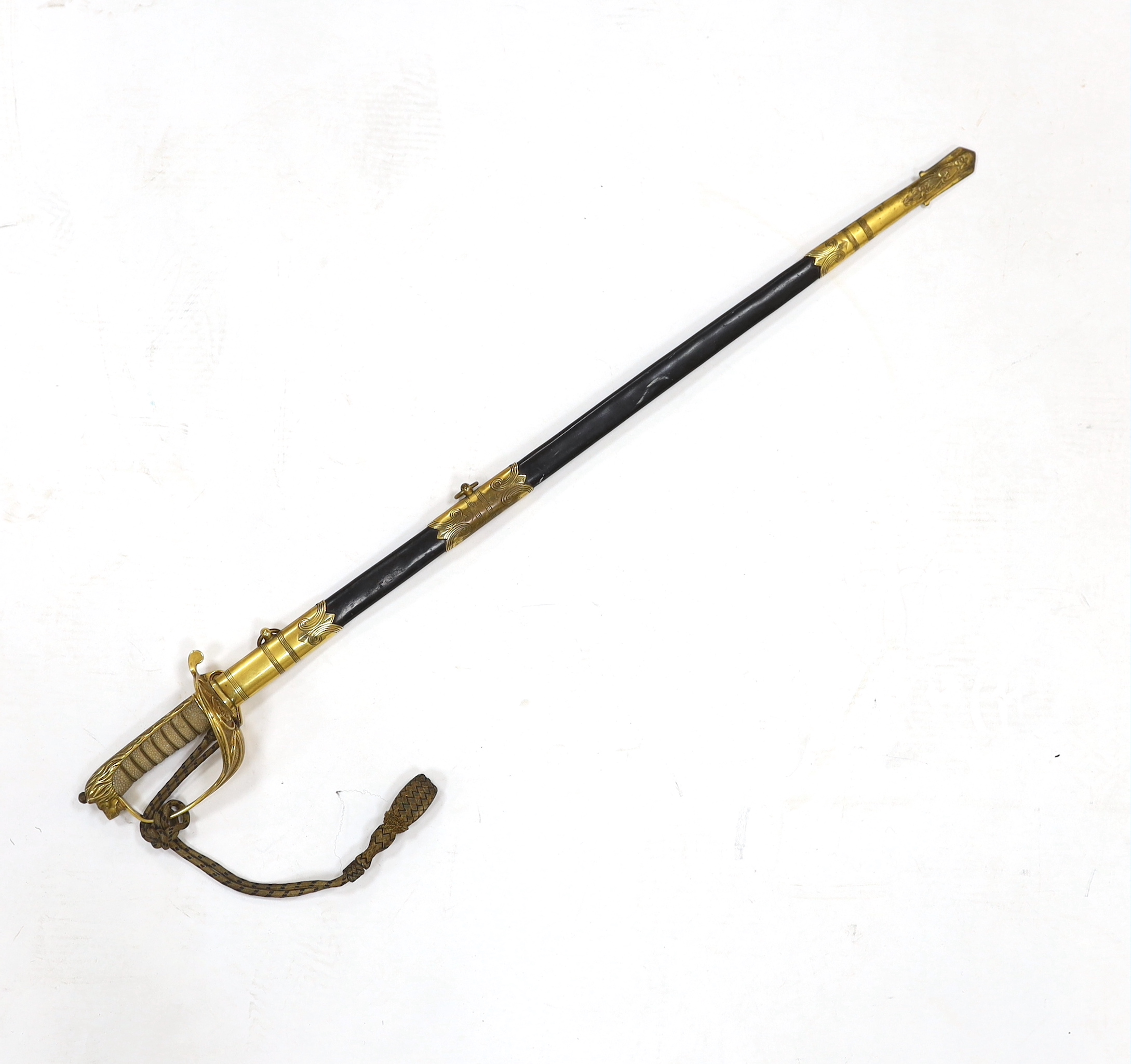 A World War I naval sword with folding guard engraved J.W. Collett R.N., regulation gilt hilt and scabbard mounts, the blade has been refinished and furniture regilded, with bullion dress knot, blade 78.5cm